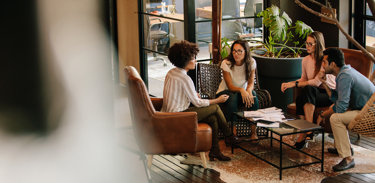 Young professionals sitting in chairs discussing career advice